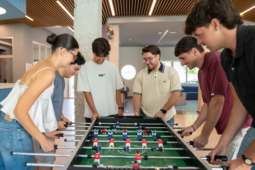 Estudiantes jugando una partida de futbolín